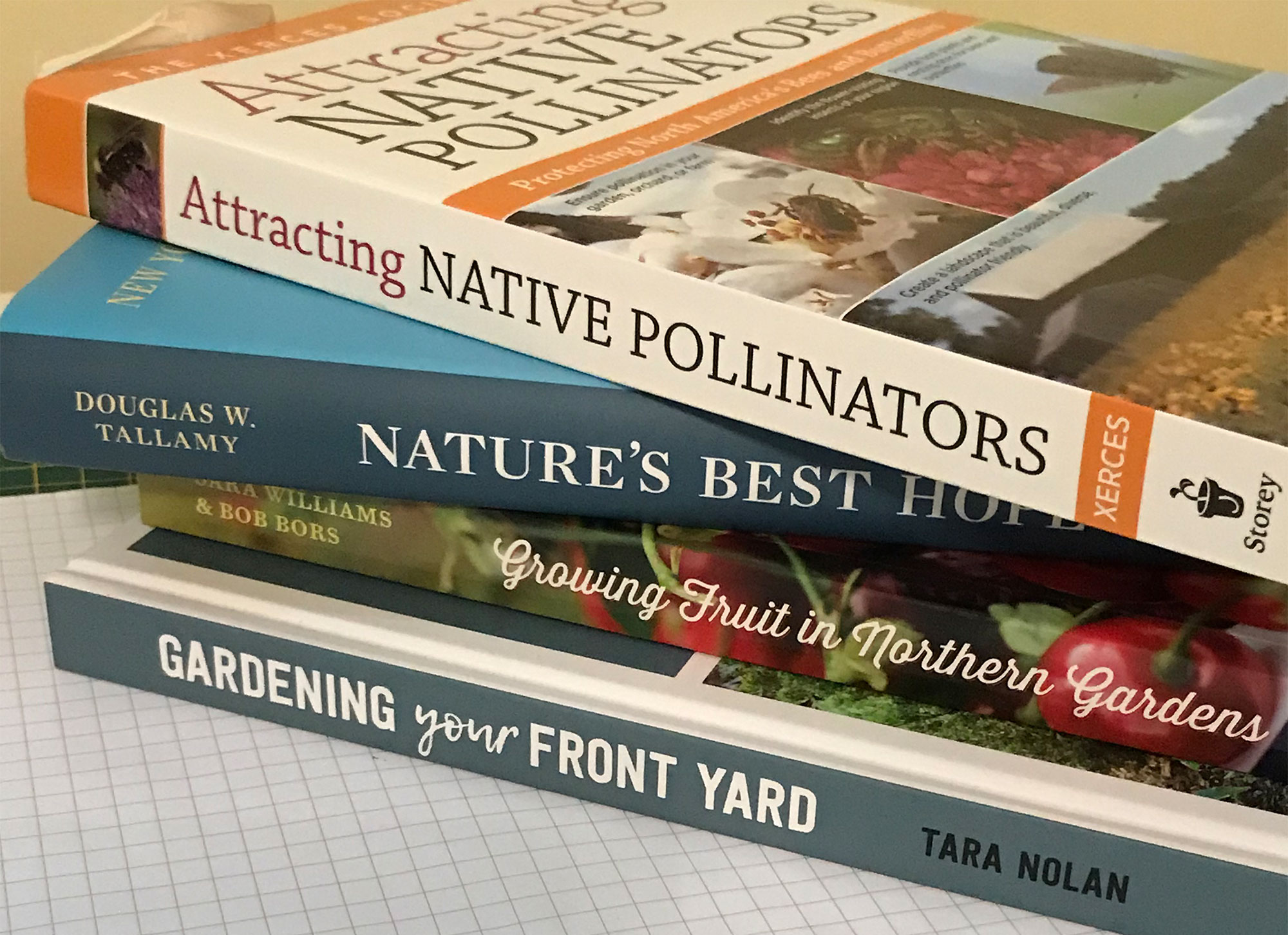 Stack of gardening books on graph paper.