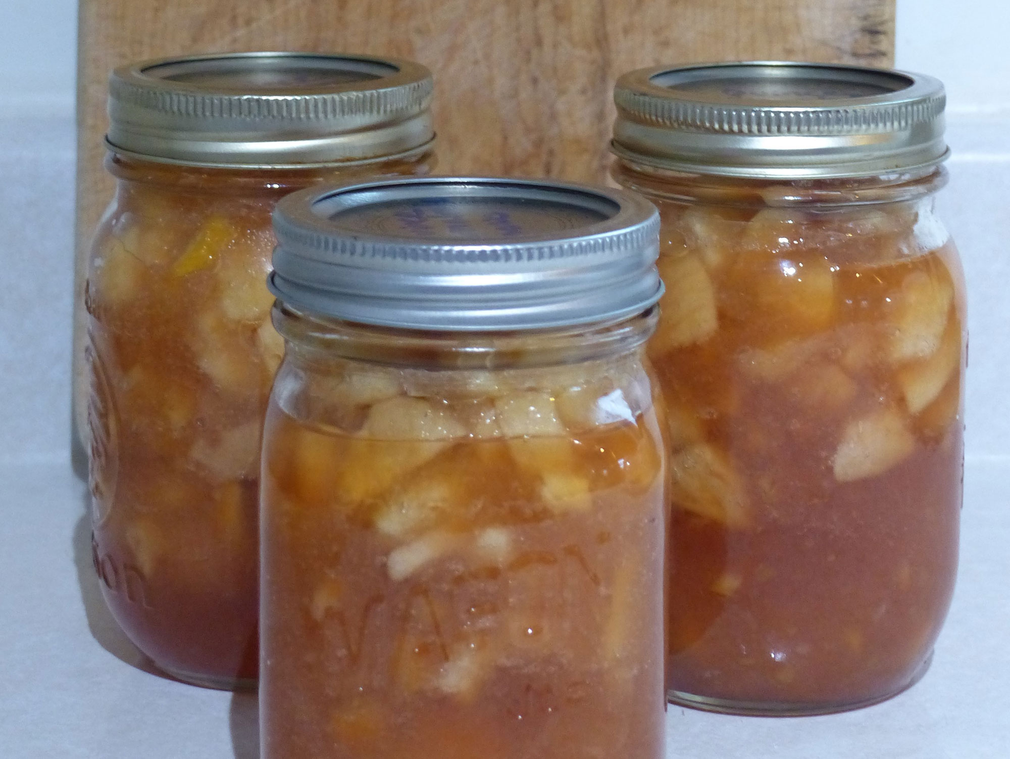 Three mason jars filled with pear marmalade.