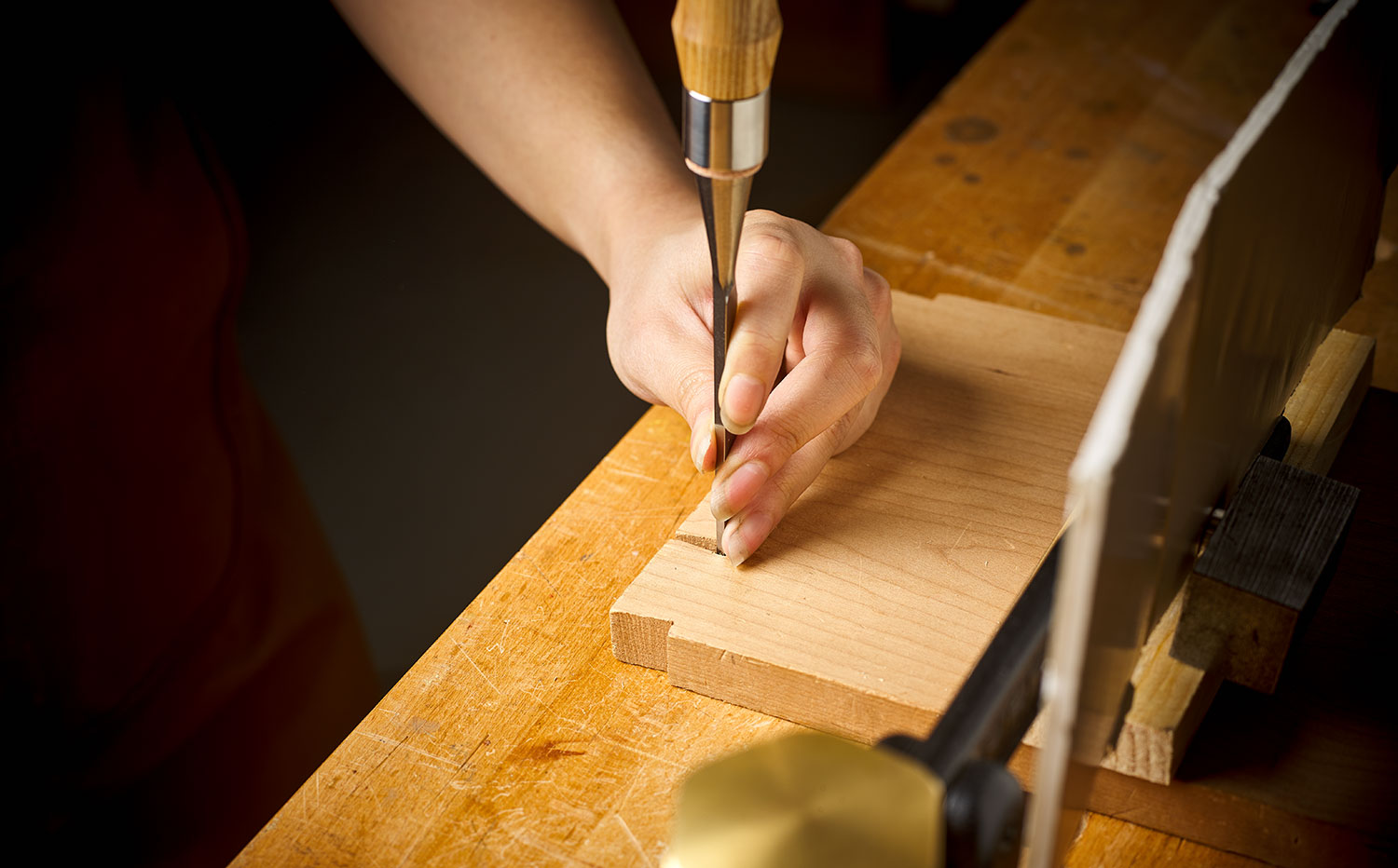 Chopping dovetail joint with a chisel and mallet.