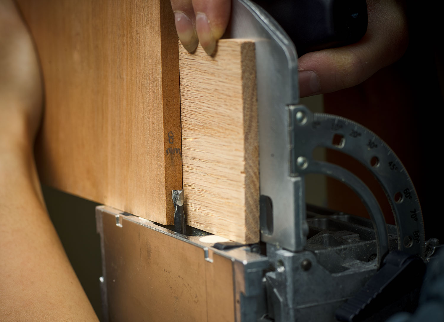 A shim offsets the cutter so it mortises in the center of the stock.
