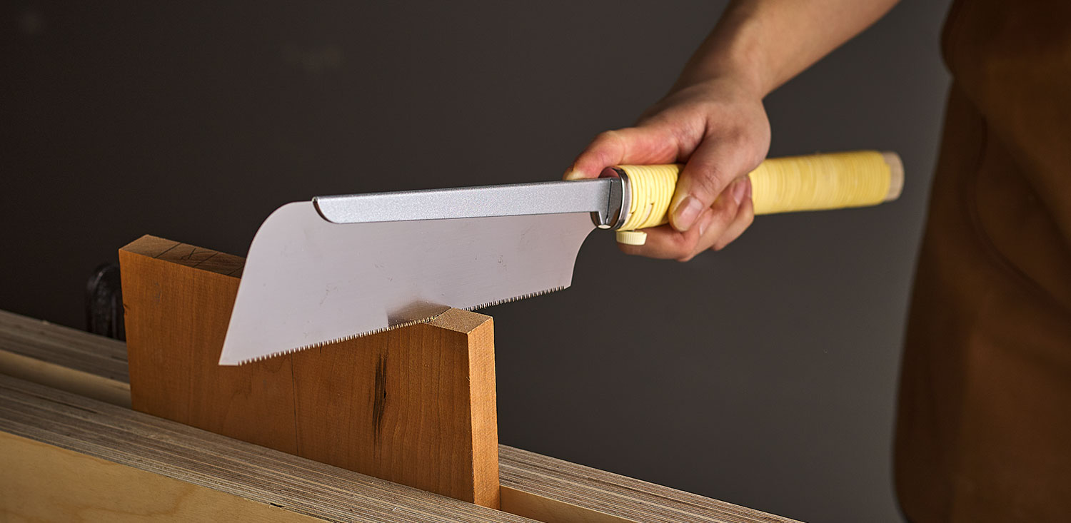 Grip with the index finger extended along the saw’s spine.