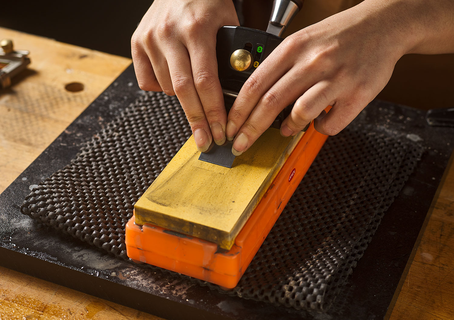 A chisel being sharpened on a Japanese water stone.