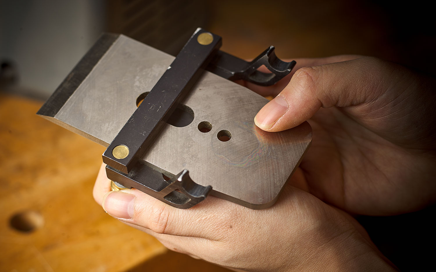A plane blade secured in the blade holder of the Veritas Mk.II power sharpening system.