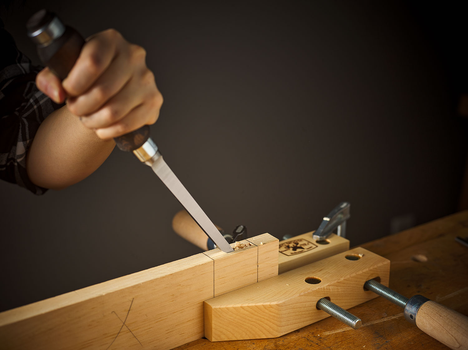 A mortise being cut into a board using a Narex chisel.
