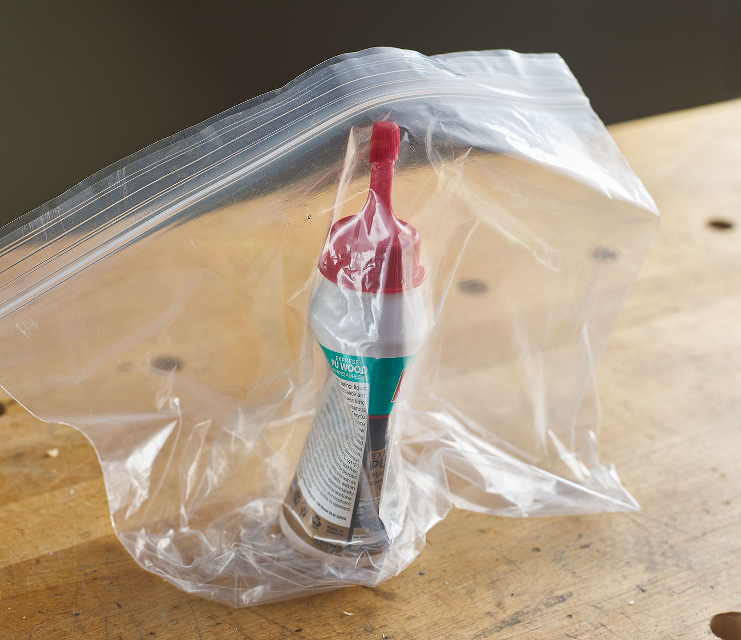 A bottle of polyurethane adhesive is sealed in a small plastic baggie.