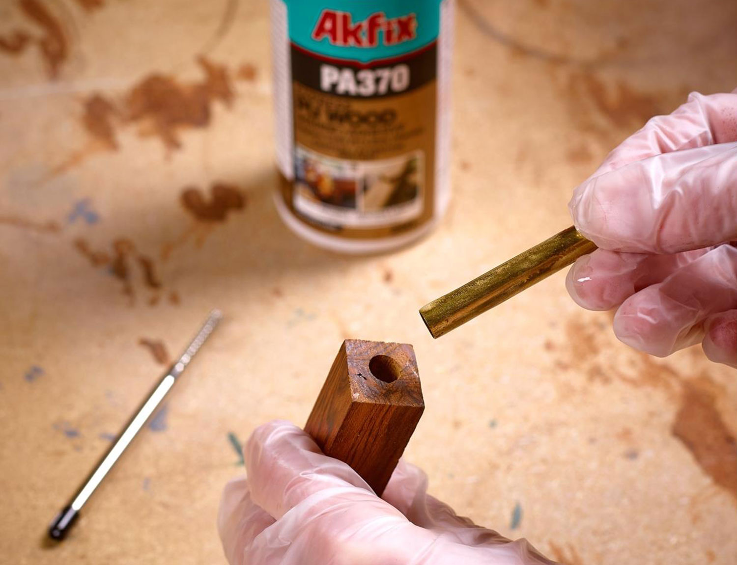 Polyurethane adhesive being applied to a pen blank.