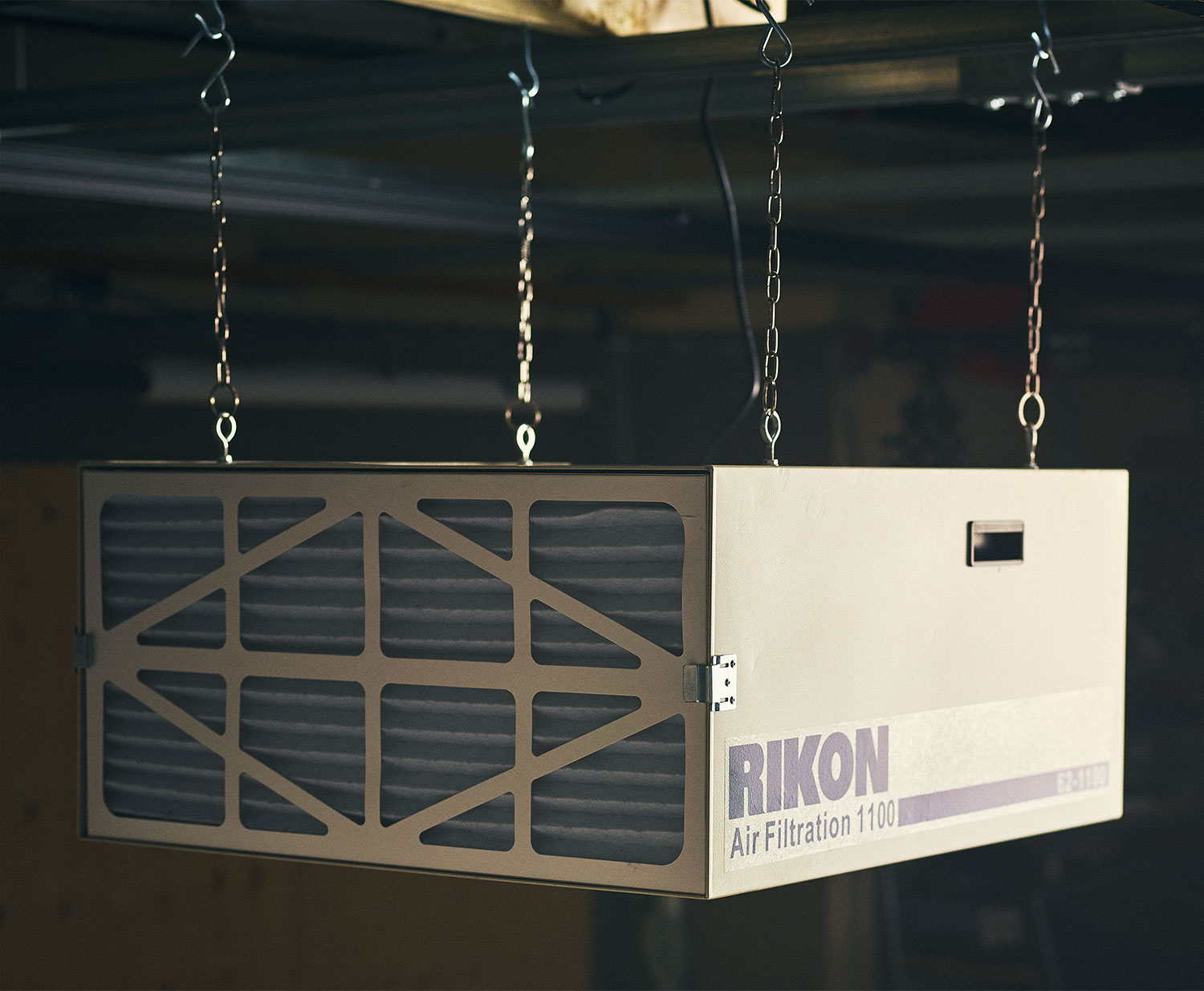 A Rikon model 62-1100 Air Cleaner hung from a workshop ceiling.