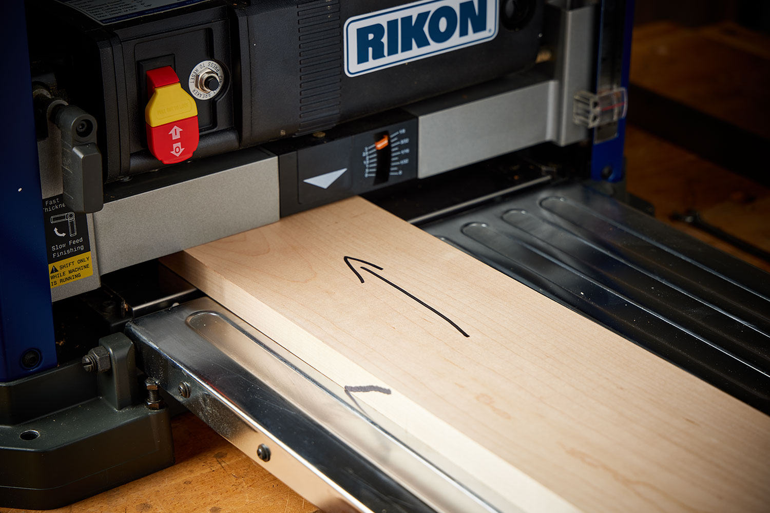 A board is passing through a Rikon helical planer.