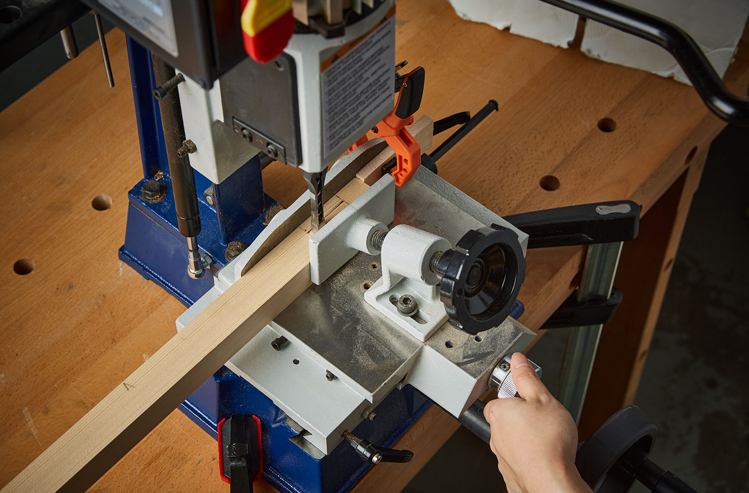Boards are clamped in the mortiser as the micro-adjust knob is turned.