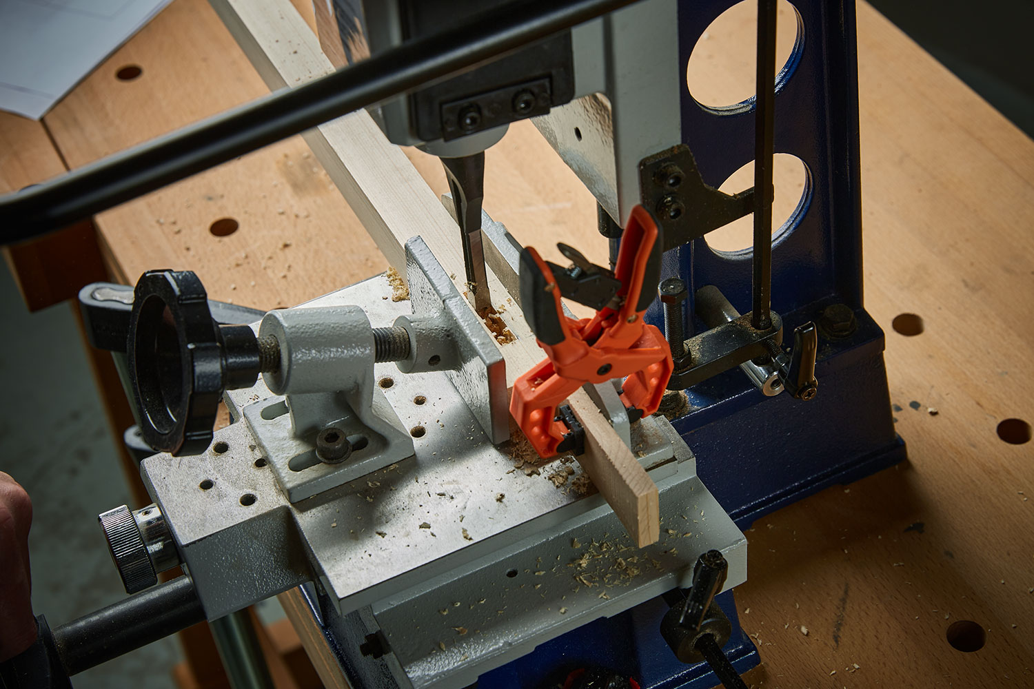 A mortise is being cut in a clamped board.