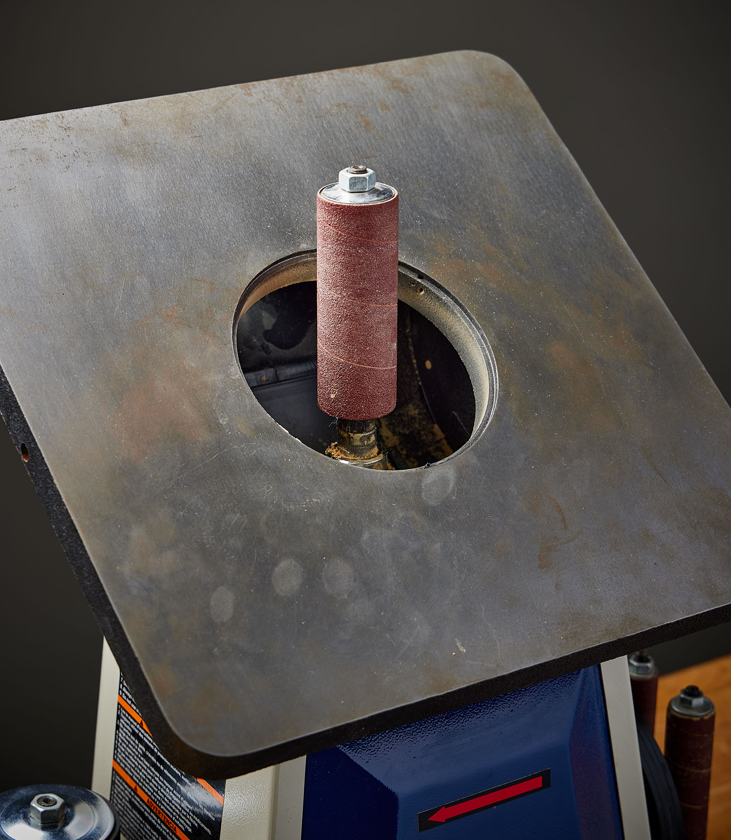 A Rikon spindle sander with the table tilted to permit access to the drum-locking bolt.