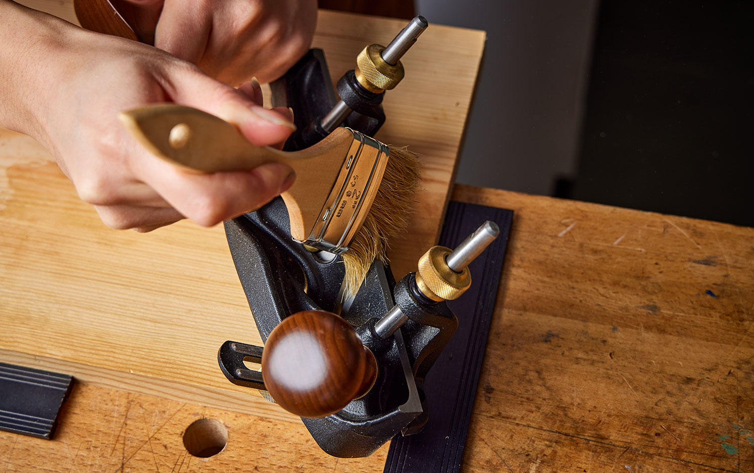 Using a paint brush to apply a coating of tool wax to a Veritas skew rabbet plane.