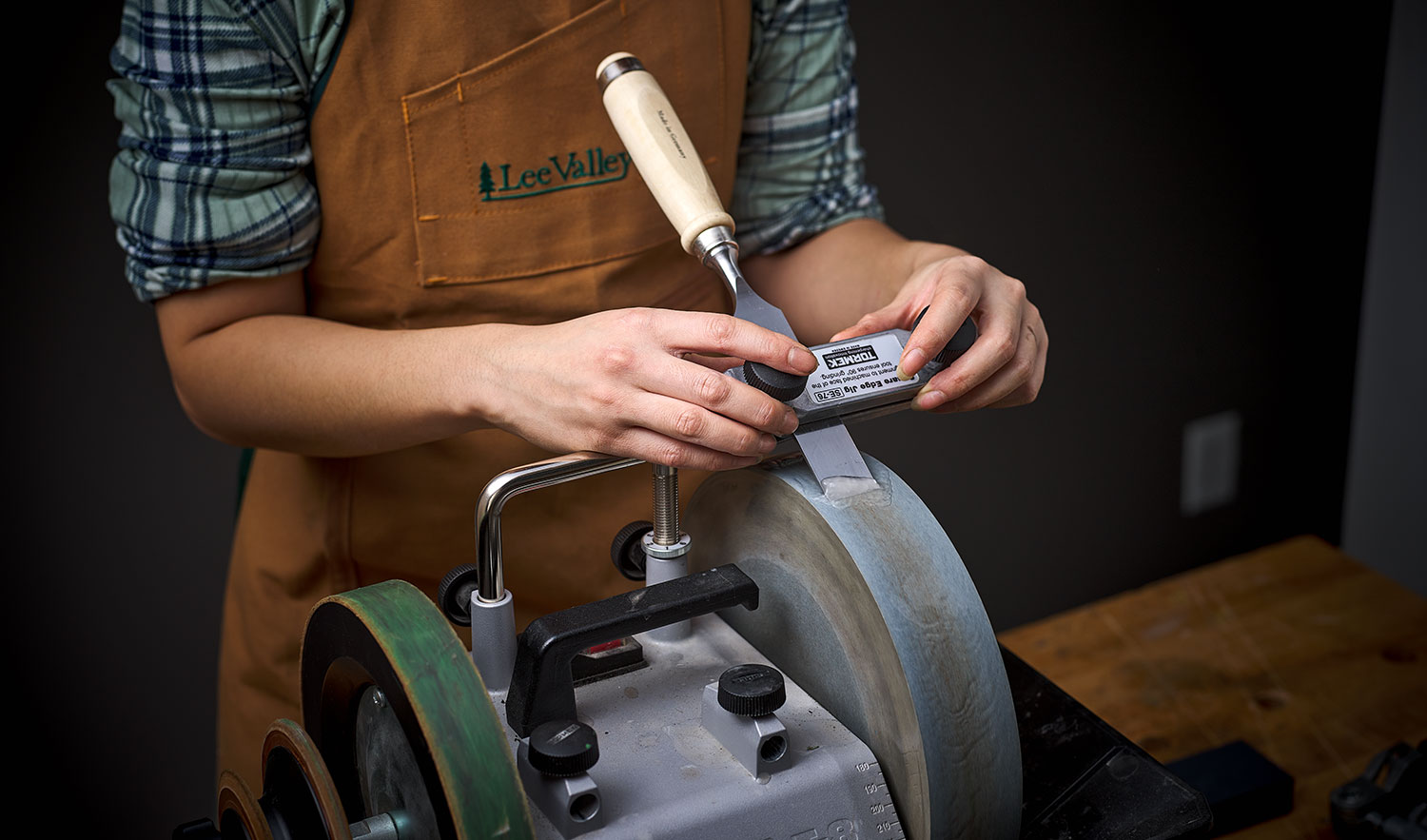 Sharpening a chisel on a T-8 sharpening machine with the tool support set in the upright position .