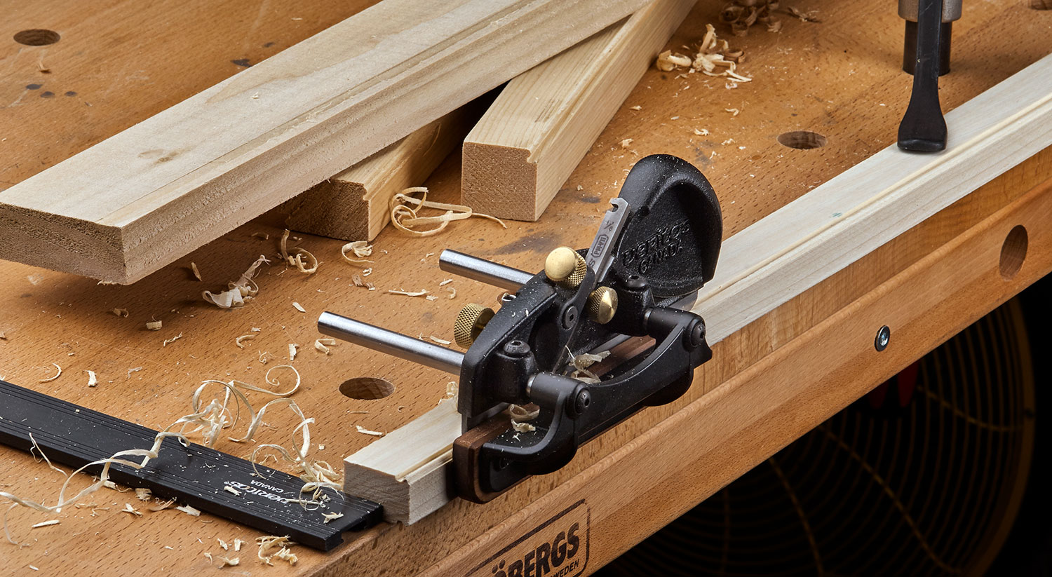 A right-hand box-maker’s plow plane being used to cut beading on the edge of a piece of wooden stock.