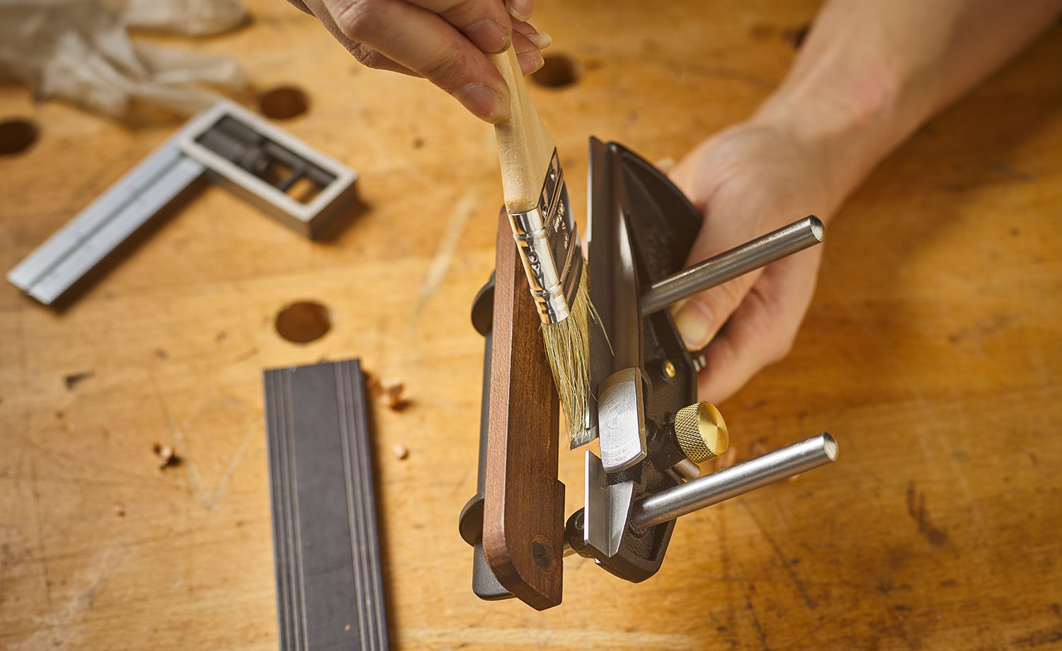 Using a paintbrush to apply a silicone-free wax to the skate of a Veritas box-maker’s plow plane.