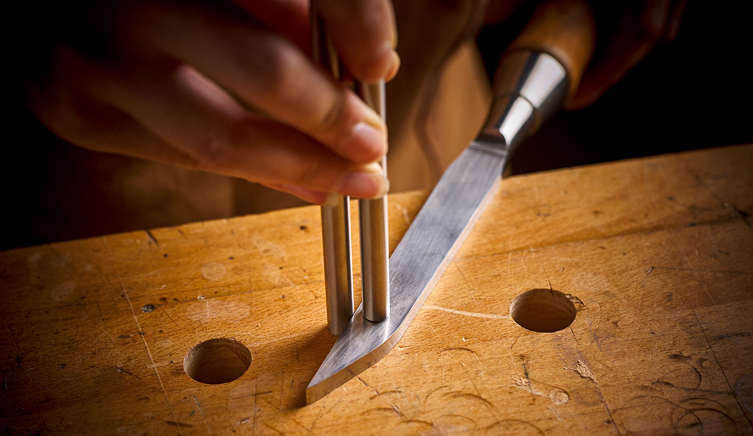 Registering a dual marking gauge against a chisel to set the wheel spacing to match the chisel width