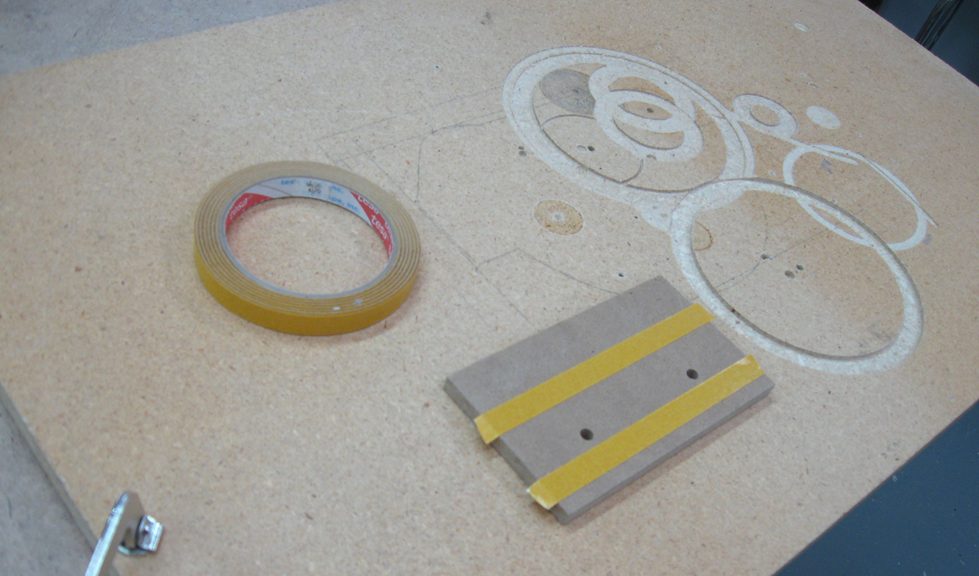 Double-sided tape used to secure workpiece to panel board.