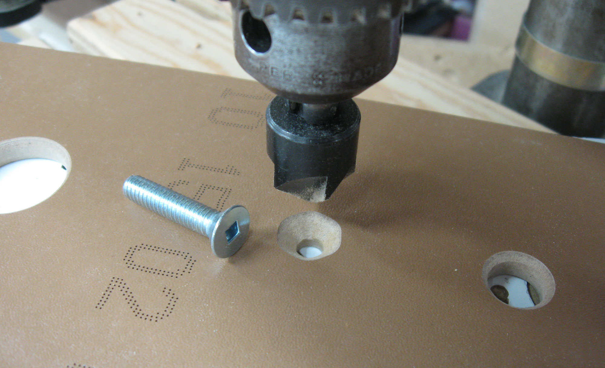 Drilled hole and 1/4" flat-head machine bolt.