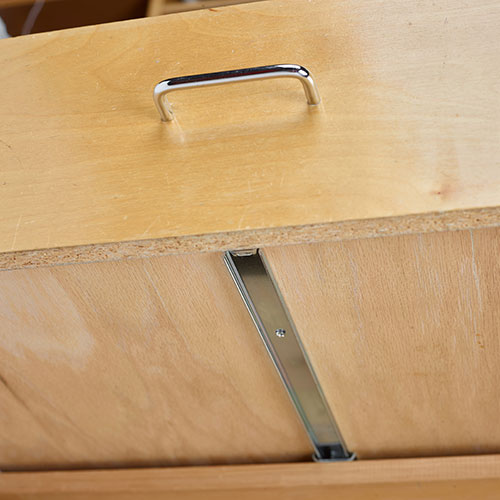 Drawer slide concealed on the bottom of a cabinet drawer