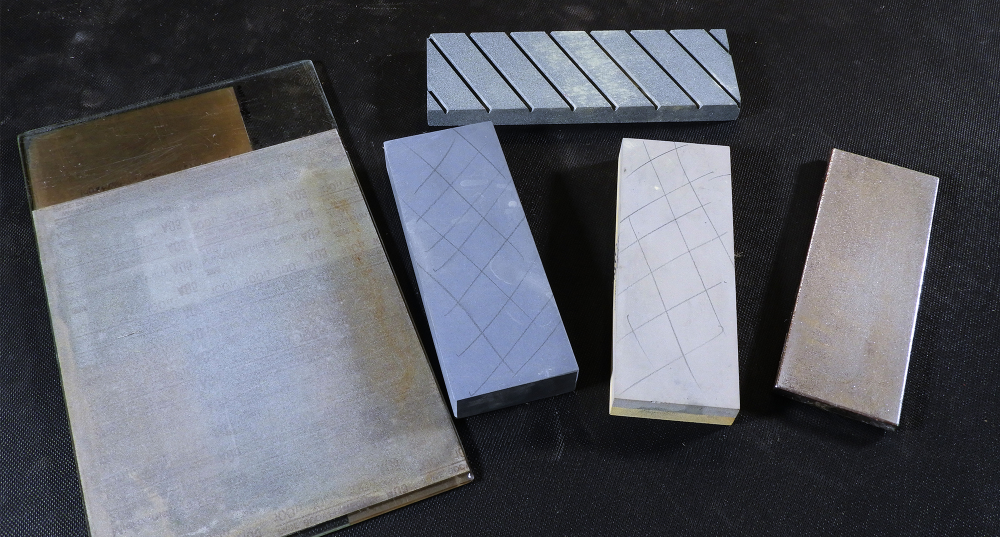 Plusieurs options pour le dressage : feuille abrasive sur plaque de verre (à gauche), pierre à dresser (en haut) et pierre diamantée (à droite)