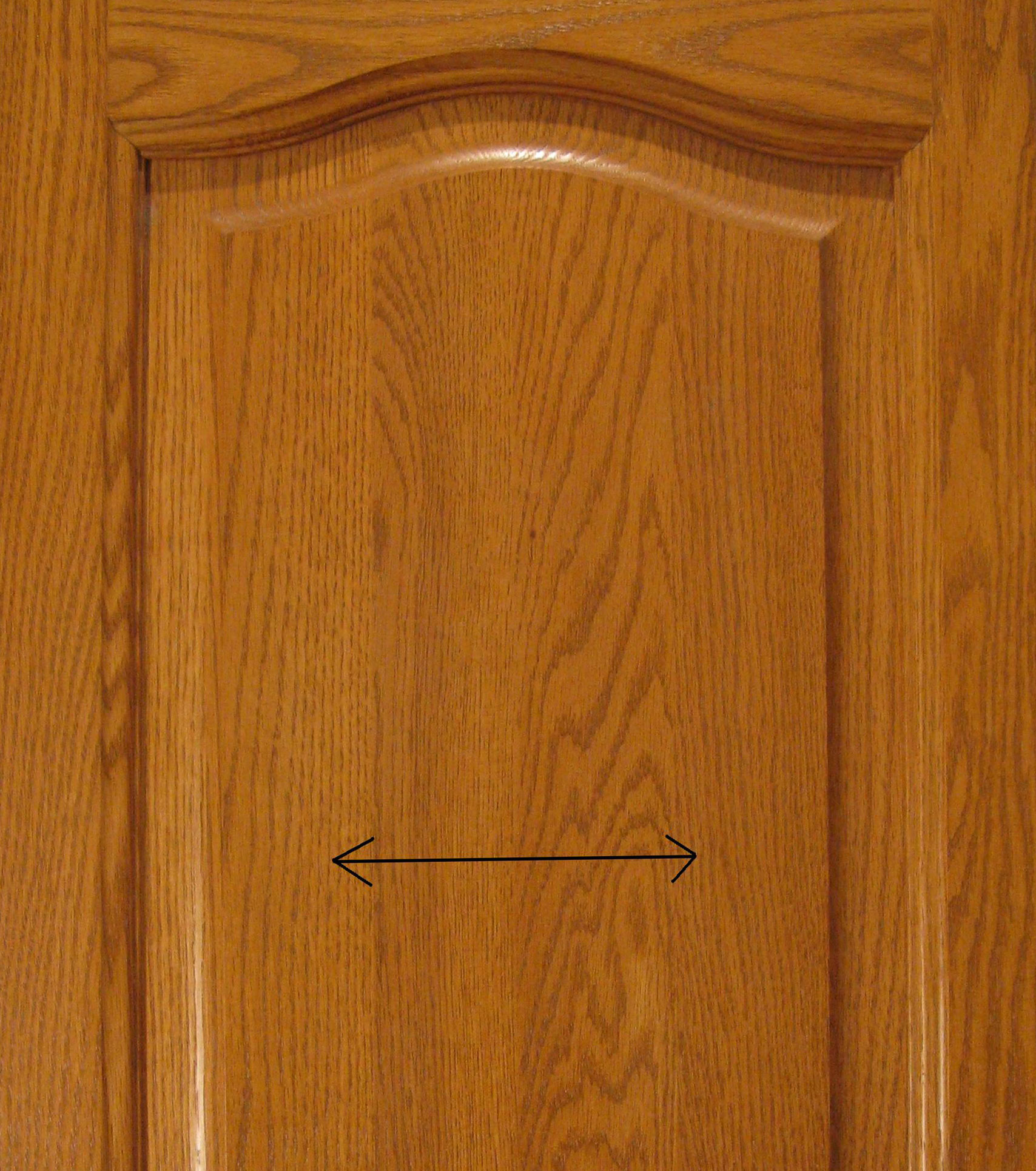 Porte d'armoire en bois massif avec des flèches indiquant le mouvement du bois